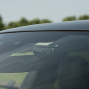 Car window with a reflection of trees and sky