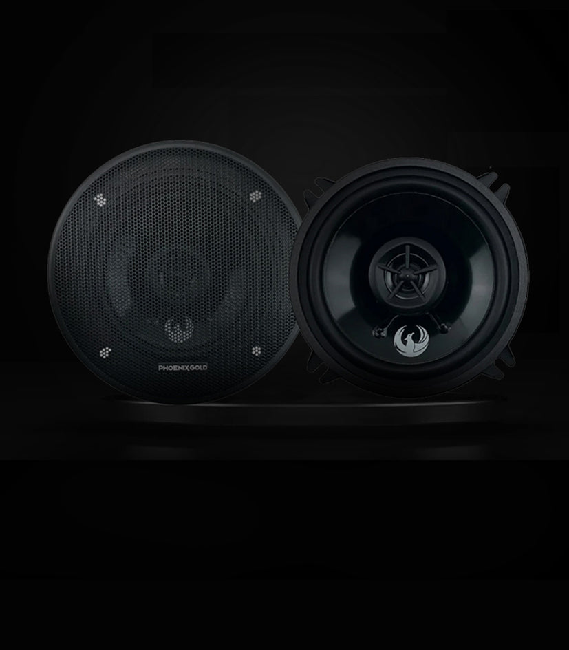 Pair of black car speakers on a dark background